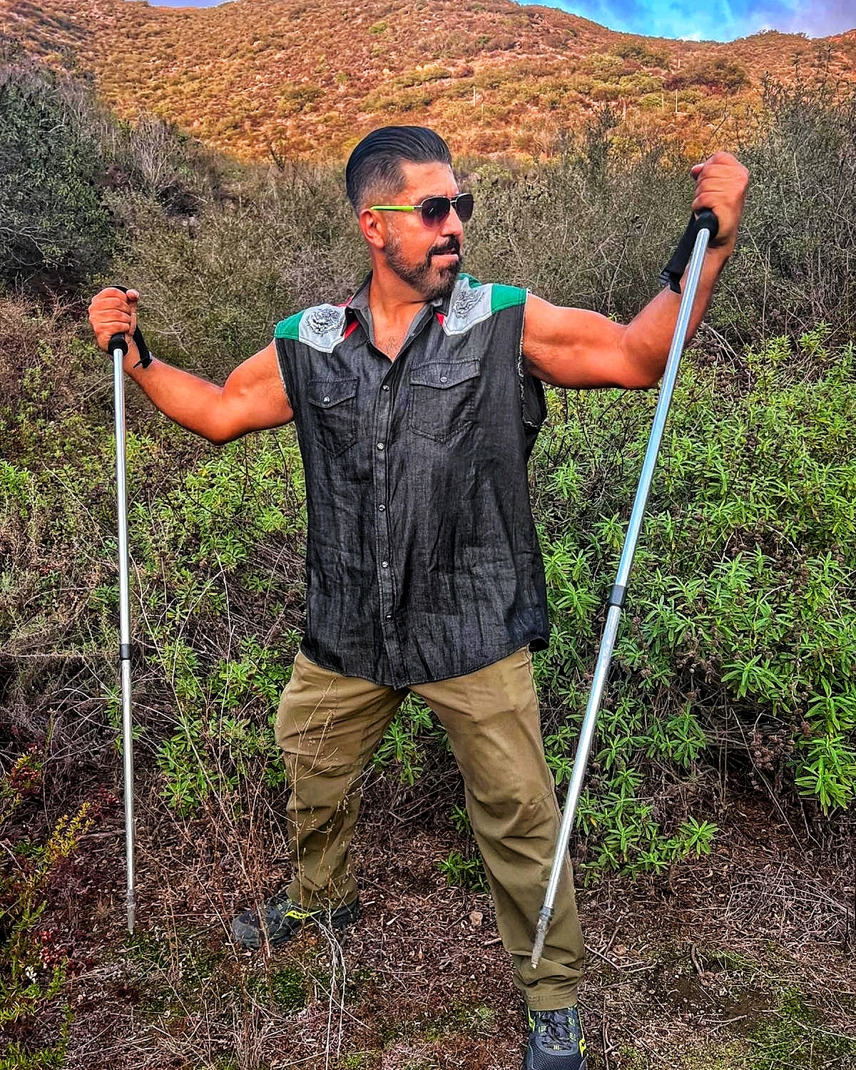 A hiker standing with trekking poles on a mountain trail