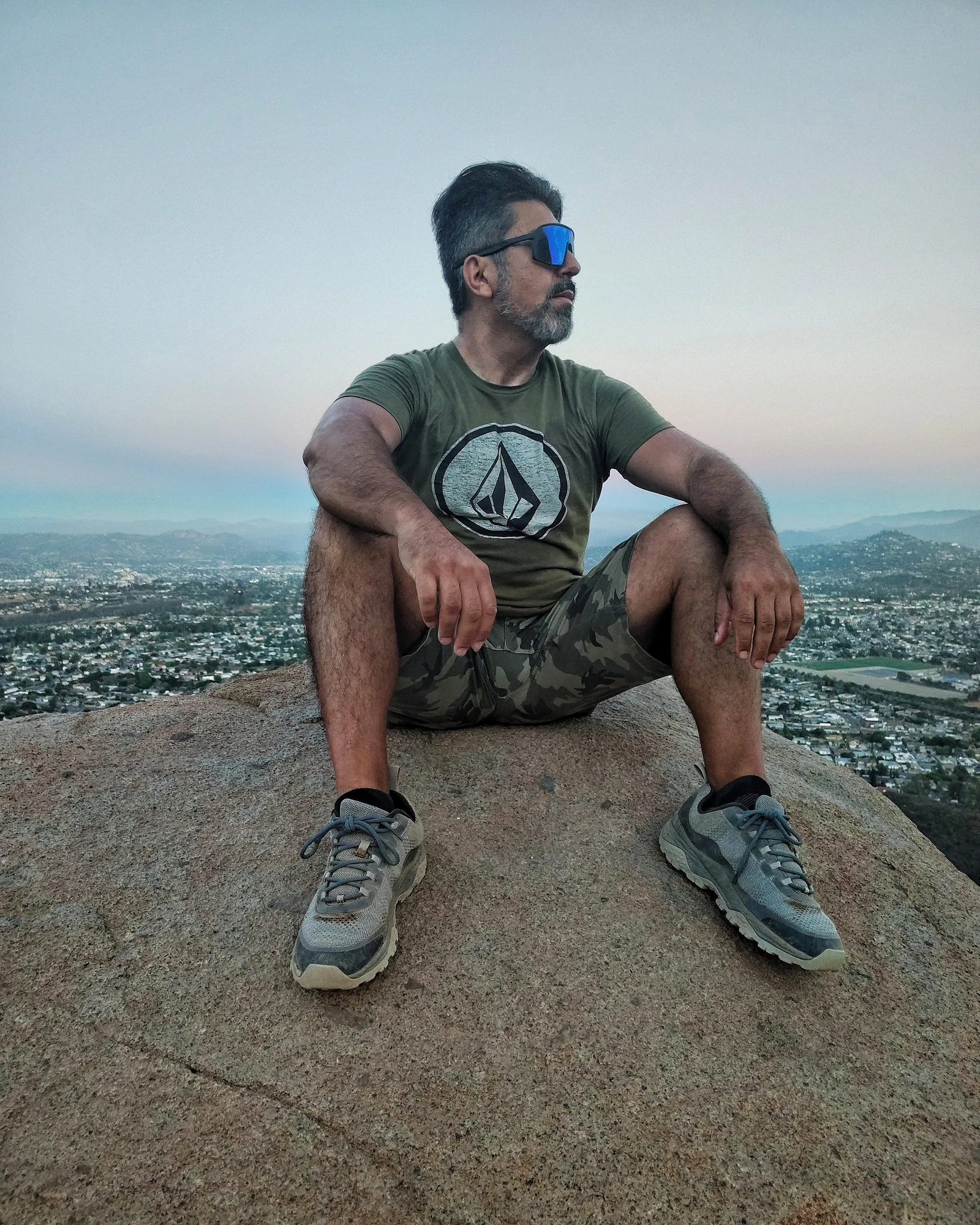 A seated environmental portrait overlooking a broad landscape